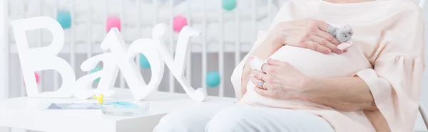 Elderly woman in infant room — Stock Photo, Image