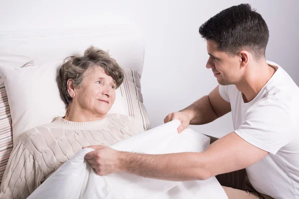 Covering grandmother with blanket — Stock Photo, Image