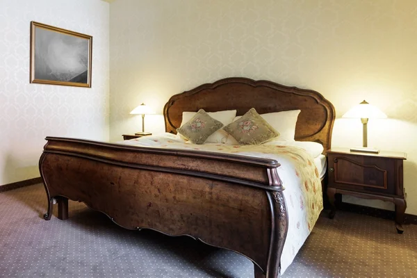 Elegant luxurious wooden double bed — Stock Photo, Image