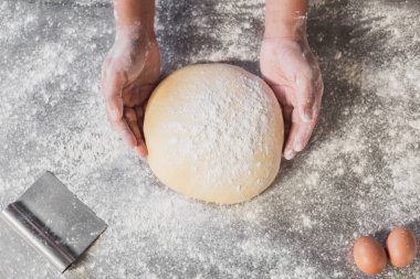 Şefin elleri hamur yoğurup mutfak masasında taze ekmek yapıyor..