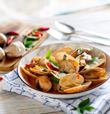 Beyaz ahşap bir masada acı biberli istiridye.