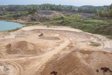 Dmitrov, Rusya - 12 Eylül 2021: Moskova 'nın Dmitrov kasabasında aktif bir kum havuzu, buldozerin diğer ağır ekipmanlar için geçişi yükselttiği yer.