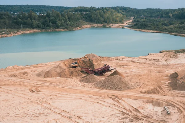 Dmitrov, Rusya - 12 Eylül 2021: Moskova 'nın Dmitrov kasabasında aktif bir kum havuzu, Kazıcı' nın kovayla kum toplayıp bir kamyona boşalttığı yer.. 