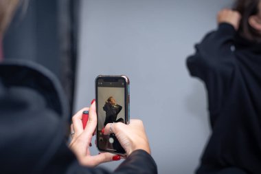 Dmitrov, Rusya - 19 Eylül 2021: iPhone 11 'de bir fotoğraf stüdyosunda çekim. Çerçevenin ortasında modelin görünür olduğu bir telefon monitörü var..