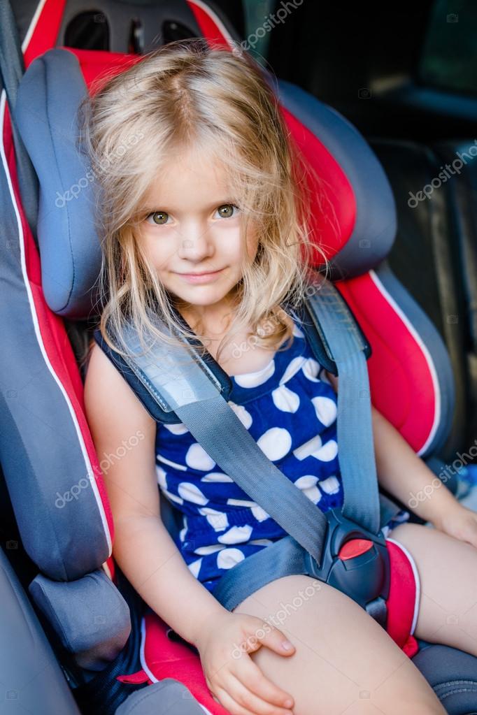 Adorable smiling little girl with long blond hair buckled in car ... Adorable smiling little girl with long blond hair buckled in car ...