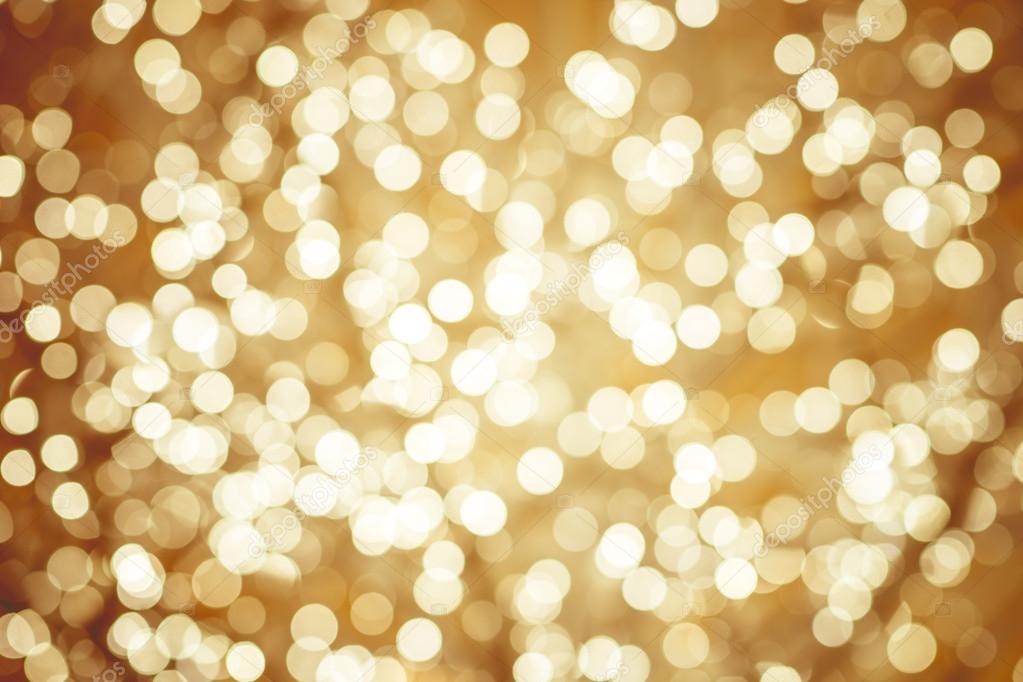 Golden background with natural bokeh defocused sparkling lights. Colorful metallic texture with twinkling lights. Bright and vivid colors