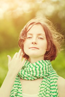 Açık yeşil ve beyaz çizgili rüzgar ile saçında şal çok güzel genç kadın portresi. Gün batımı, turuncu ve sarı renkli doğal tonlama yaz