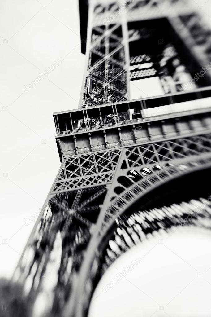 Blurred shot of the Eiffel Tower in Paris, France, selective focus on details. Lensbaby photo of Eiffel Tower, vintage black and white colors
