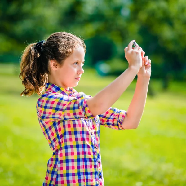 Hermosa chica adolescente tomando fotos con teléfono inteligente en el día soleado en el parque de verano. Chica adolescente tomando selfie con teléfono inteligente —  Fotos de Stock