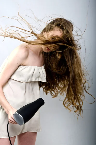 The girl plays with the hair dryer with hair — Stock Photo, Image