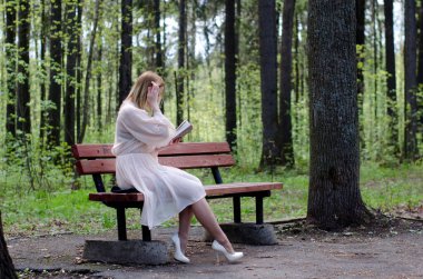 Parktaki genç kız elinde bir kitapla