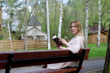 Parktaki genç kız elinde bir kitapla