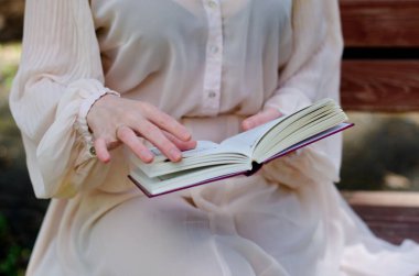 Parktaki genç kız elinde bir kitapla