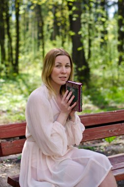 Parktaki genç kız elinde bir kitapla