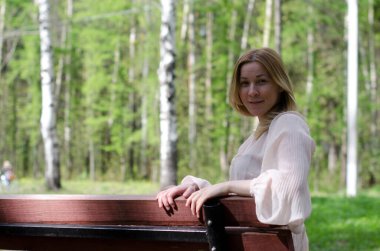 Parktaki genç kız elinde bir kitapla