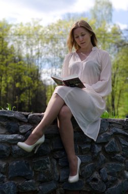 Parktaki genç kız elinde bir kitapla