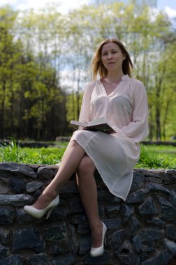 Parktaki genç kız elinde bir kitapla