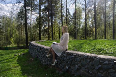 Parktaki genç kız elinde bir kitapla