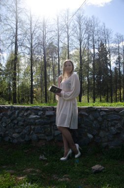 Parktaki genç kız elinde bir kitapla