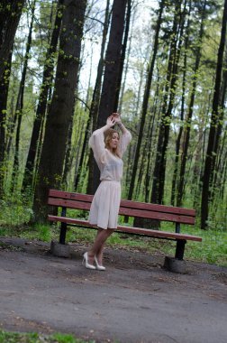 Parktaki genç kız elinde bir kitapla