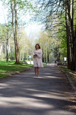 Parktaki genç kız elinde bir kitapla