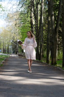 Parktaki genç kız elinde bir kitapla