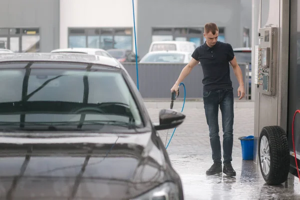 Araba yıkama. Shinig için yüksek basınçlı cilayı kullanarak araba temizlemek. Adam dışarıda arabasını yıkıyor. — Stok fotoğraf