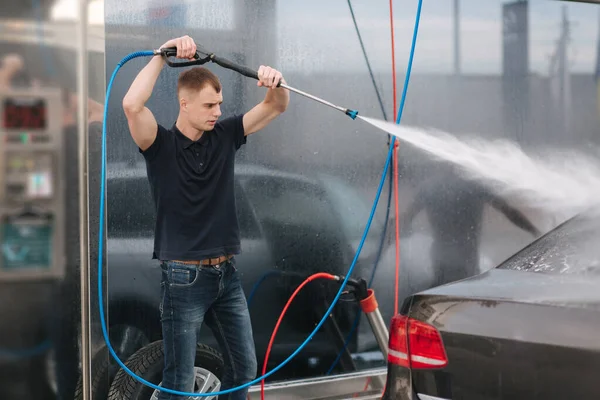 Araba yıkama. Shinig için yüksek basınçlı cilayı kullanarak araba temizlemek. Adam dışarıda arabasını yıkıyor. — Stok fotoğraf