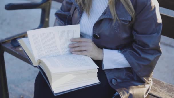 Κλείστε το χέρι των γυναικών, ενώ διαβάζετε το βιβλίο. Θηλυκό κάθισμα στον πάγκο — Αρχείο Βίντεο