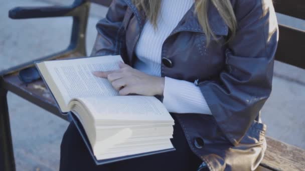 Κλείστε το χέρι των γυναικών, ενώ διαβάζετε το βιβλίο. Θηλυκό κάθισμα στον πάγκο — Αρχείο Βίντεο