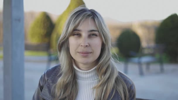 Mujer sentada en el parque y probándose gafas. Rubia pelo mayor hembra — Vídeo de stock