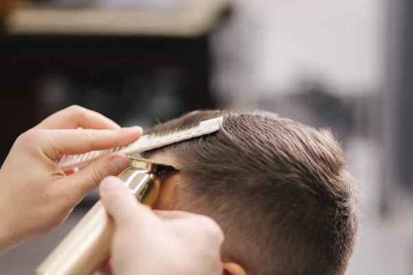 A professzionális fodrász hajvágót használ egy jóképű szakállas férfinak. Borbélyüzlet — Stock Fotó