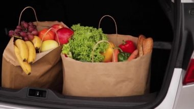 Araba bagajındaki süpermarketten aldıklarım. Karantina sırasında yemek teslimatı. Alışveriş için kağıt eko poşetler. Taze meyve ve sebze, vejetaryen.
