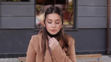 Güzel bir kadın kahve içerken koruyucu maskesini çıkarır. Terasta oturan ve kahve içen bir kadın. Karantina, mesafeli. Covid 19