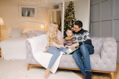 Baba, anne ve oğlunun Noel ağacının yakınındaki bir arabada otururken portresi, hepsi gülümsüyor. Noel ailesi. Mutluluk