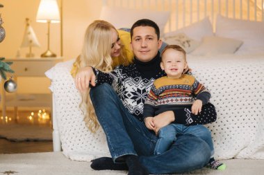 Genç aile Noel zamanı evde vakit geçirir. Mutlu anne, baba ve oğul enjoyng aşk kucaklaşmaları, tatilciler. Birliktelik kavramı