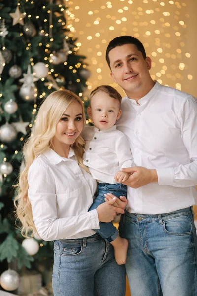 Retrato de papá, mamá e hijo en casa cerca del árbol de Navidad, todos sonríen. Familia navideña. Felicidad —  Fotos de Stock