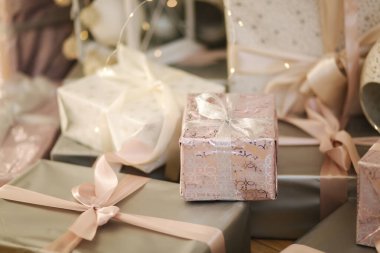 Noel için güzel hediyelerin yakın çekimi. Oda da köknar ağacının yanında yerde duran güzel Noel hediye kutuları.