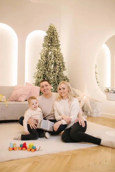 Feliz família bonita de mãe, pai e filho se divertir em casa no tempo Chrisrmas. Família elegante em belo quarto decorado — Fotografia de Stock