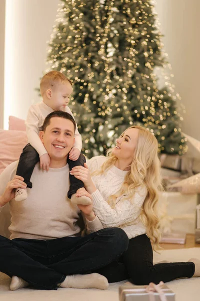 Feliz família bonita de mãe, pai e filho se divertir em casa no tempo Chrisrmas. Família elegante em belo quarto decorado — Fotografia de Stock