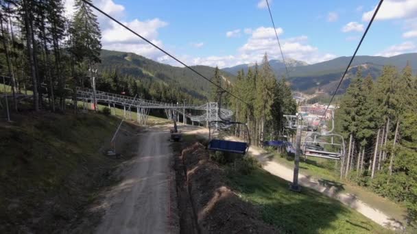 View from ski resort lift cabins in a mountain sunny autumn day. Lift movement over green grass. Slowly movement of cable car in woods. Concept vacation traveling tourism holiday — Stock Video