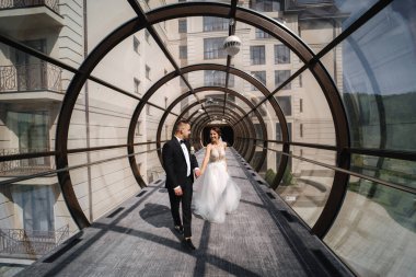 Mutlu, evli bir çift düğün gününde güzel bir pencerenin önünde yürüyor.