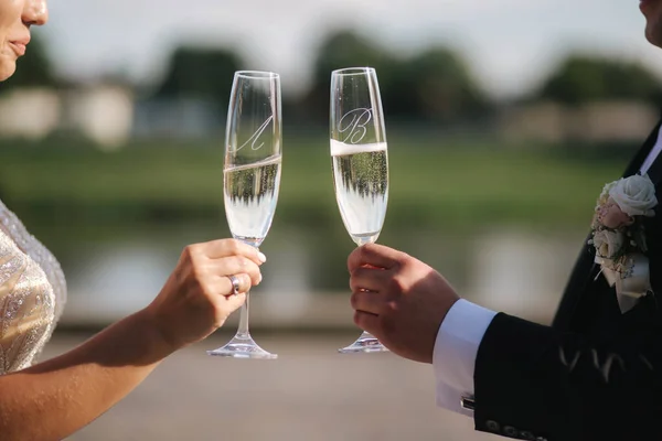 Gros plan du marié et de la mariée tiennent des verres de champagne — Photo