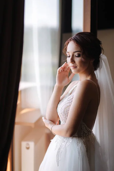 Retrato de novia elegante en pie vestido de novia de moda en el balcón y posando para el fotógrafo — Foto de Stock