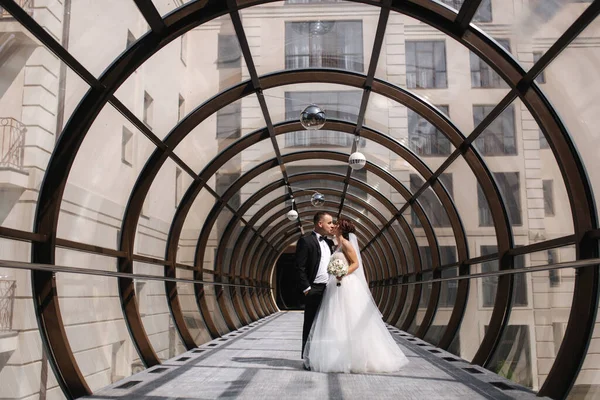 Felice coppia appena sposata a piedi bella finestra rotonda nel giorno del matrimonio — Foto Stock