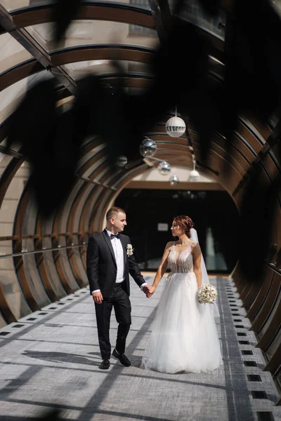 Felice coppia appena sposata a piedi bella finestra rotonda nel giorno del matrimonio — Foto Stock