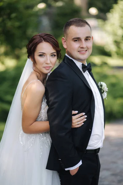 Sposa elegante con bello sposo elegante camminare all'aperto e divertirsi. Matrimonio coppia — Foto Stock