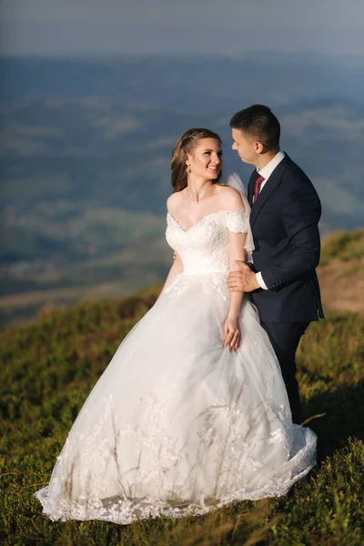 Casamento casal nas montanhas. Noiva e noivo em pé na colina — Fotografia de Stock