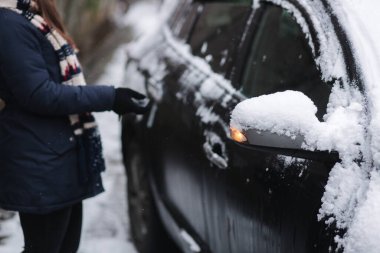 Kadın uzaktan kumandayla açık araba kullanıyor. Arabanın anahtarını tutan kadına yaklaş. Kış açık havada