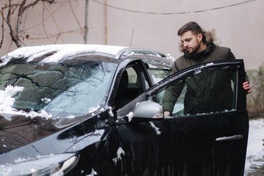 Adam arabanın kapısını açtı ve oturmaya çalıştı. Açık havada Winte